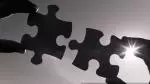 Both hands hold each puzzle piece