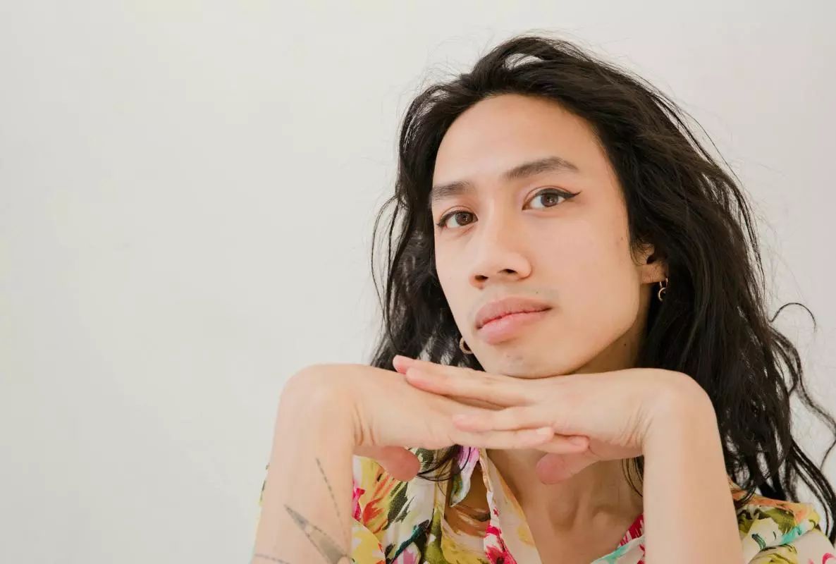 headshot of someone with long dark hair and a floral shirt
